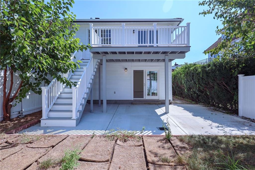 a view of a house with wooden deck and furniture