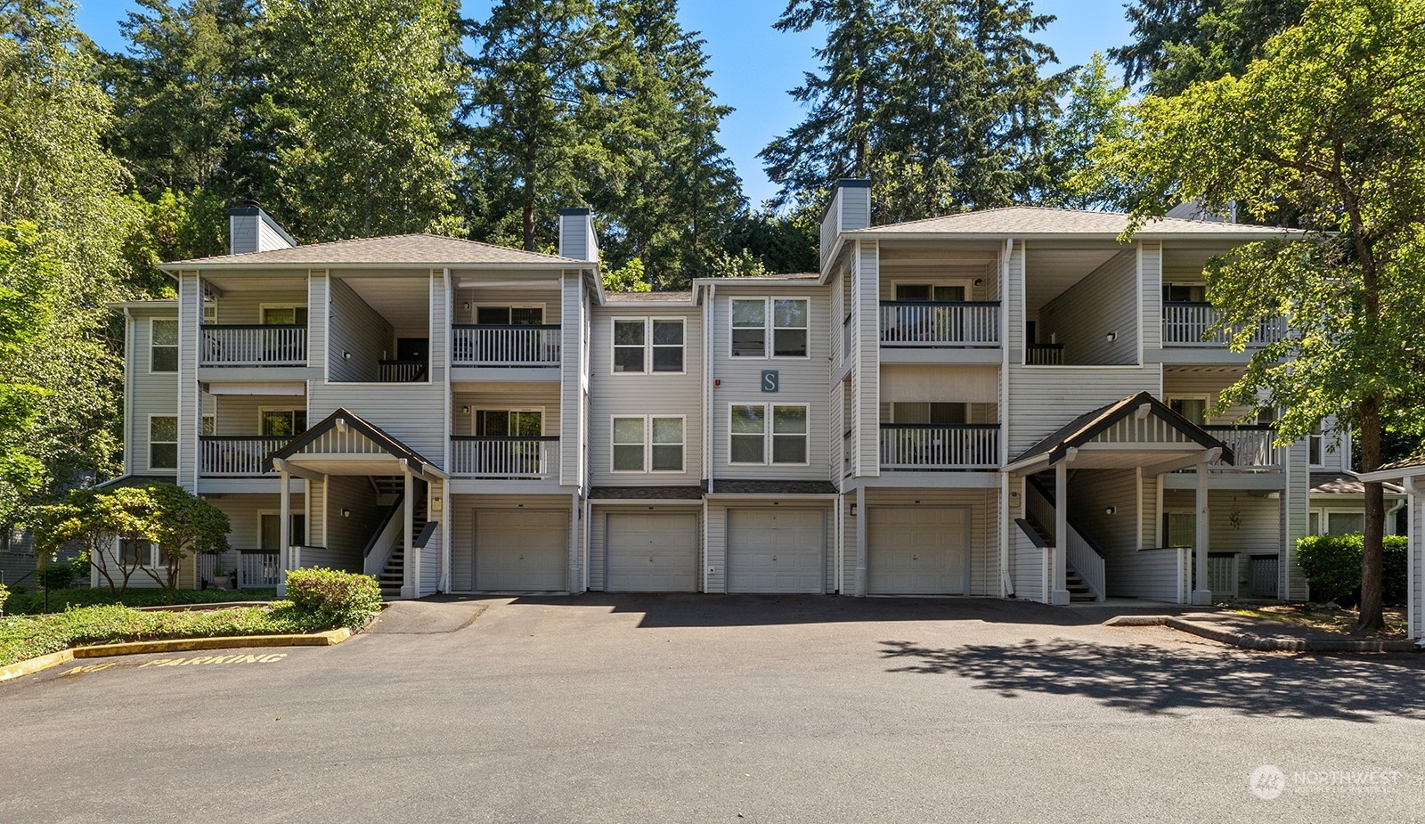 a front view of a house with a yard and parking space