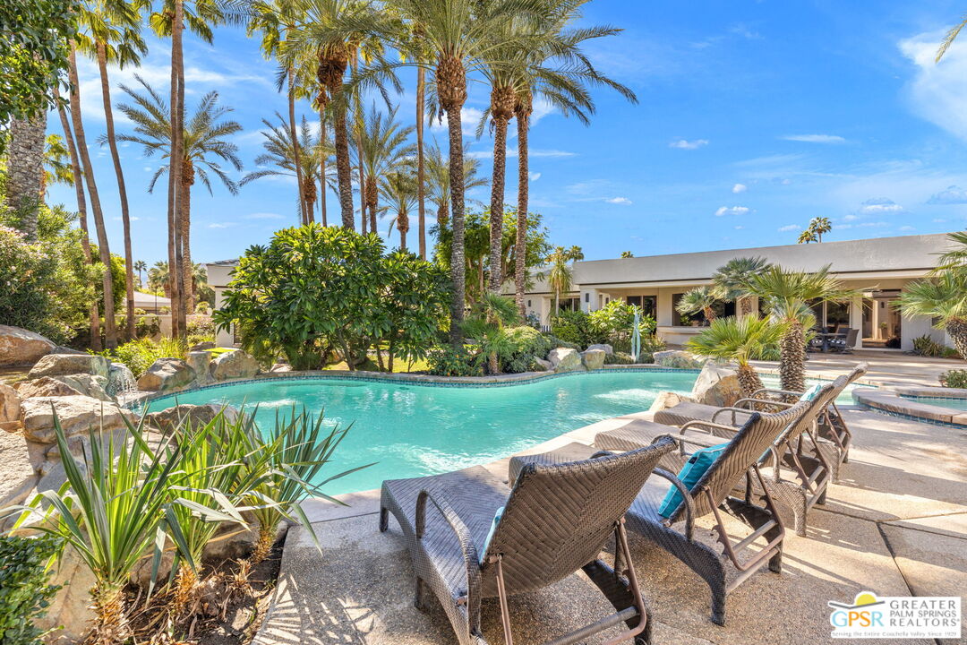 a view of a patio with table and chairs potted plants and palm trees