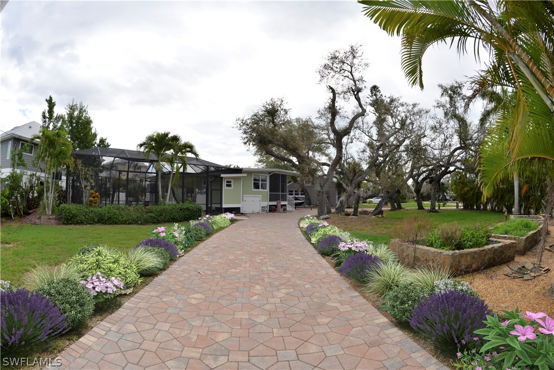 a front view of a house with fountain and garden