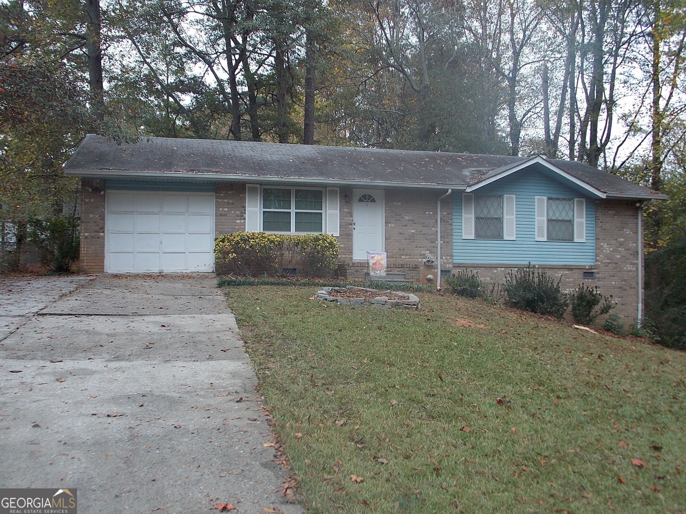 a front view of a house with a garden and yard