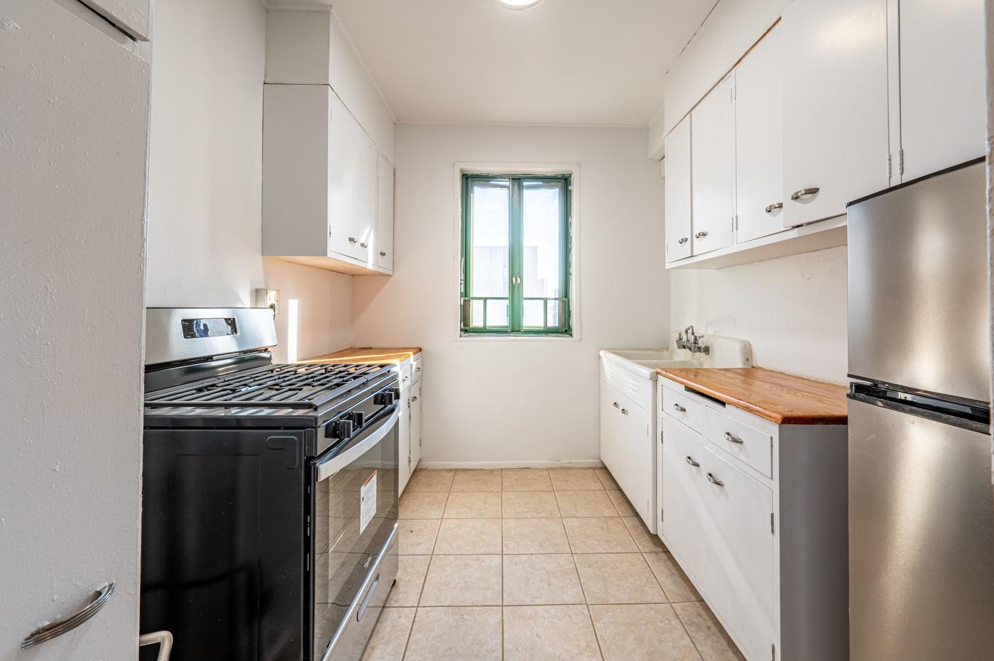 a kitchen with granite countertop a sink stove and refrigerator