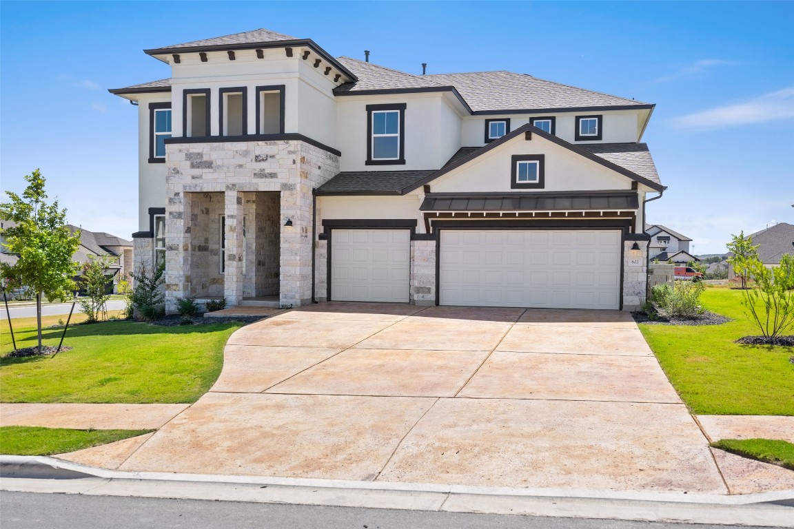 a front view of a house with a yard and garage