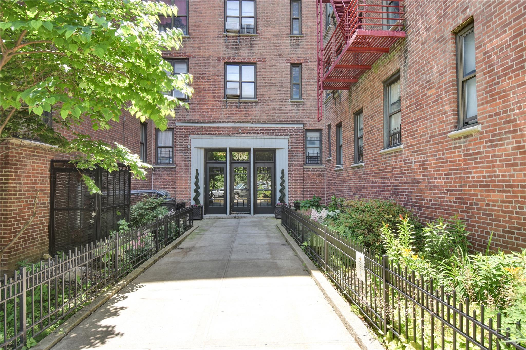 a view of a brick house with plants and large windows