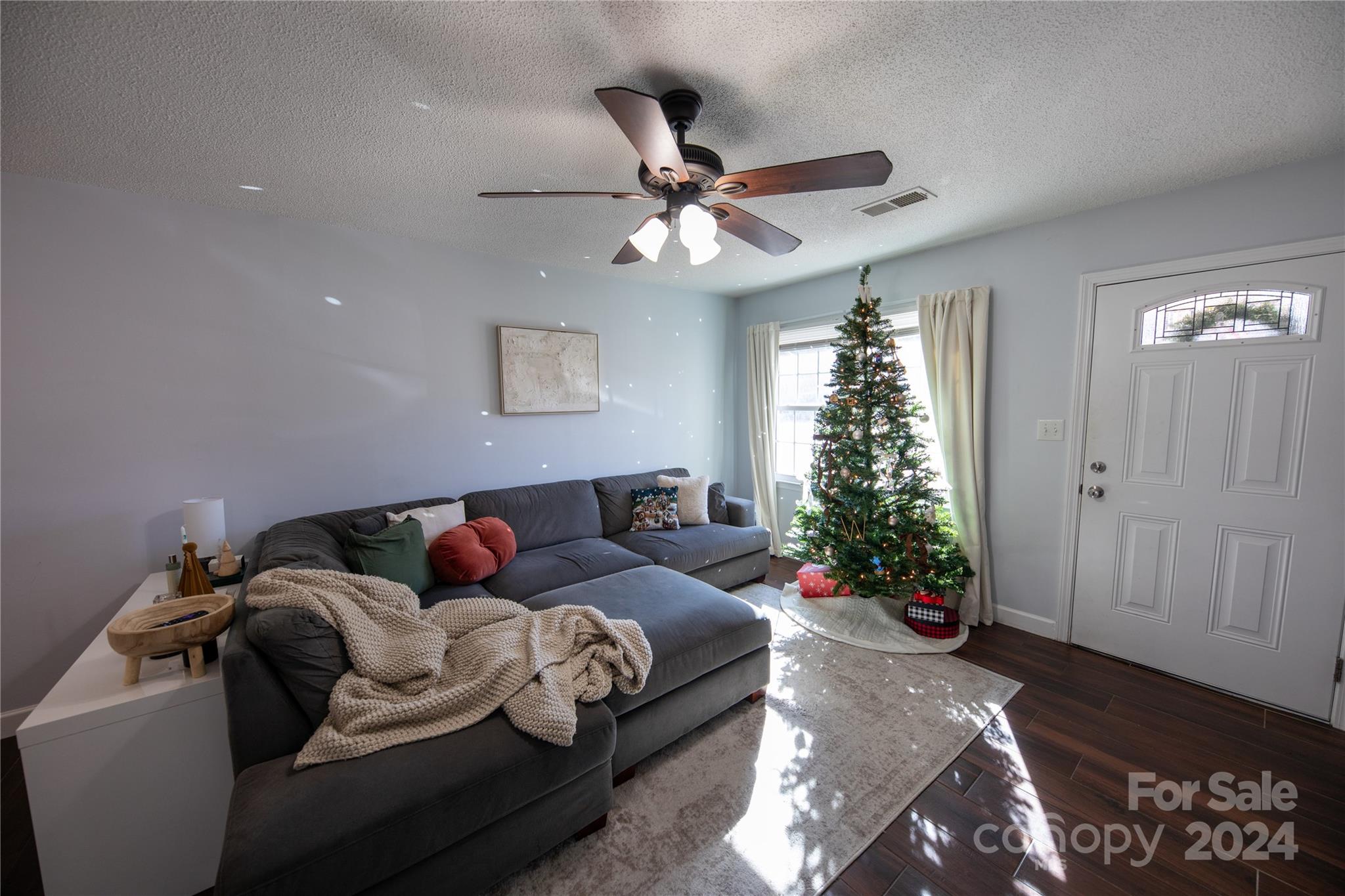 a living room with furniture flowers and a potted plant