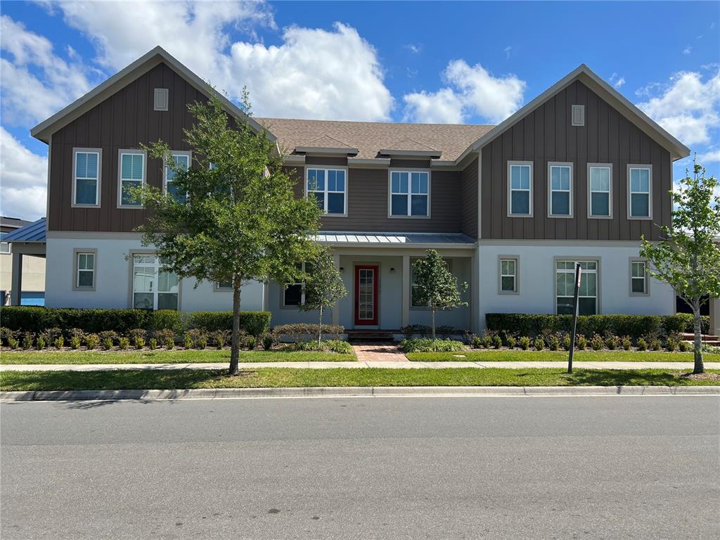 a front view of a house with a yard and potted plants