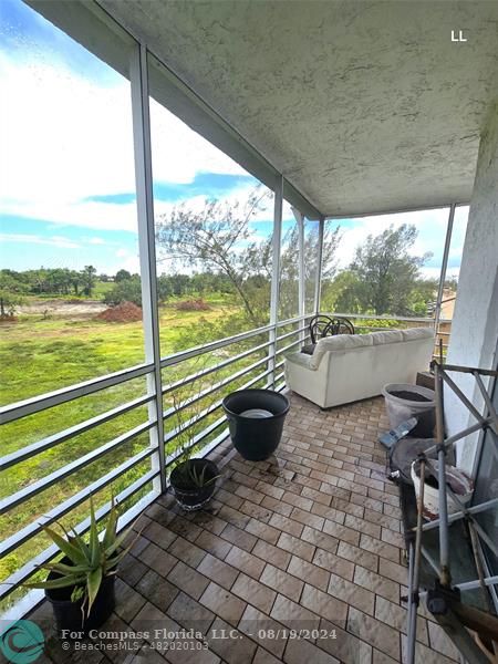 a view of a porch with furniture and a backyard