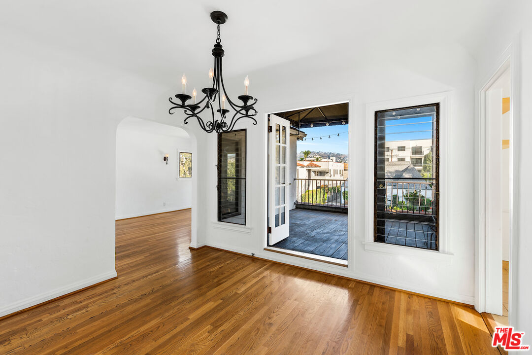 a view of a hallway with wooden floor and a chandelier