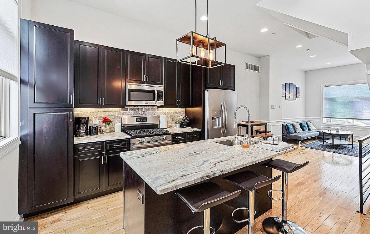 a kitchen with granite countertop a stove refrigerator and microwave