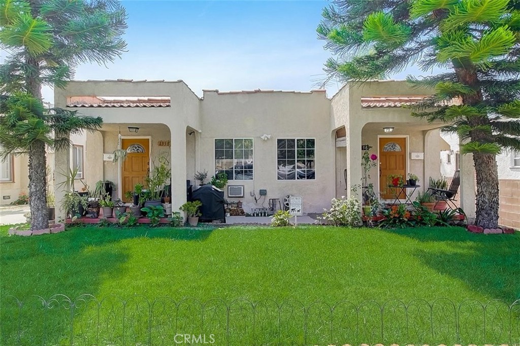 a view of a house with a big yard and potted plants