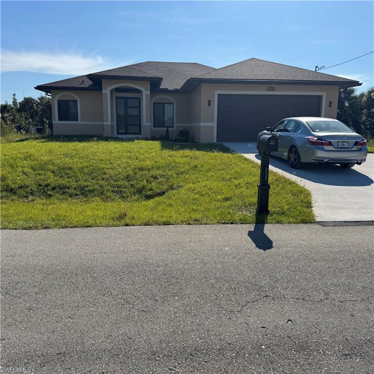 a front view of a house with a yard and garage