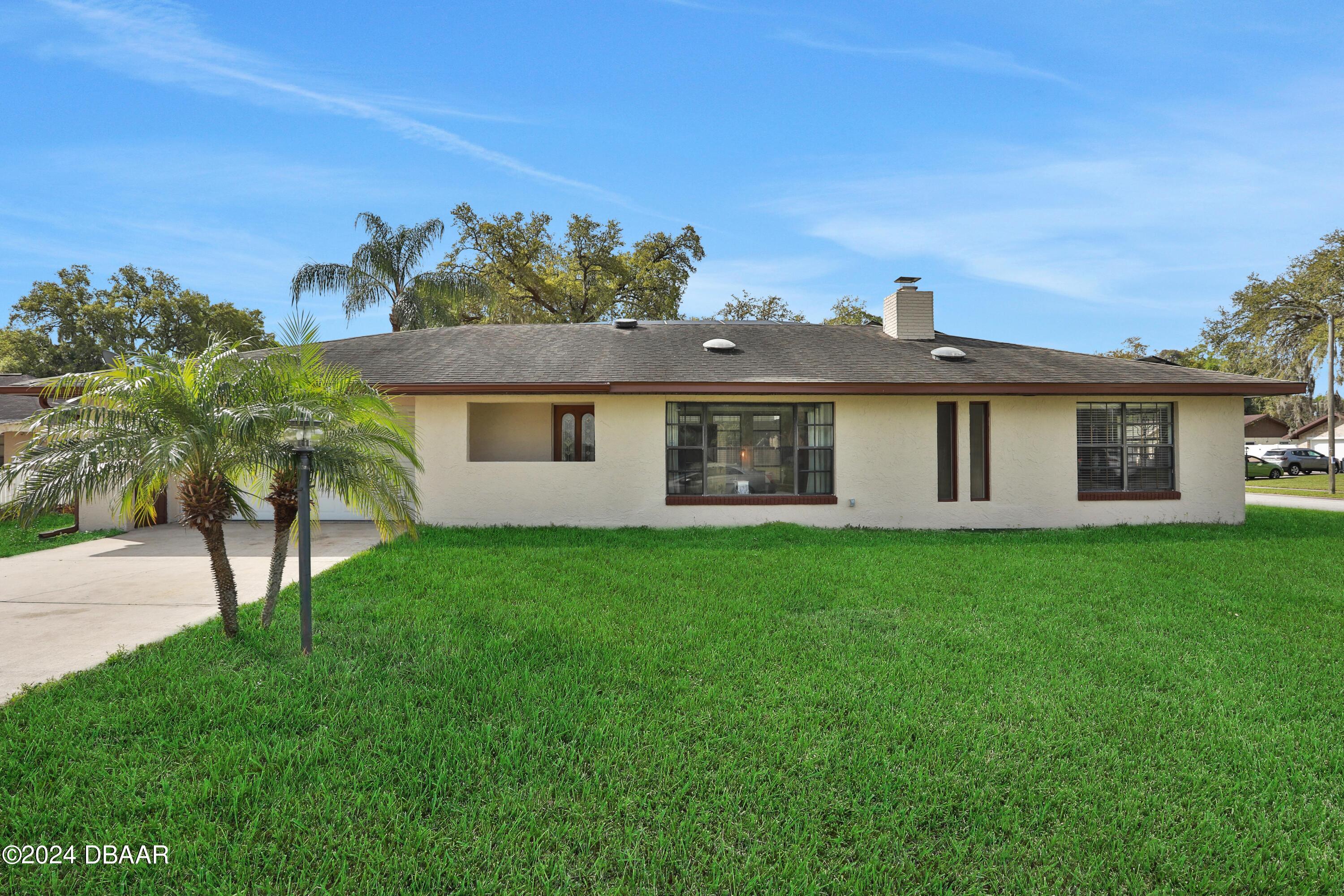 a view of a house with a backyard