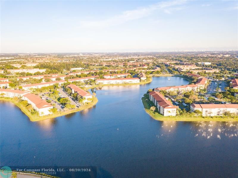 an aerial view of ocean and residential houses with outdoor space