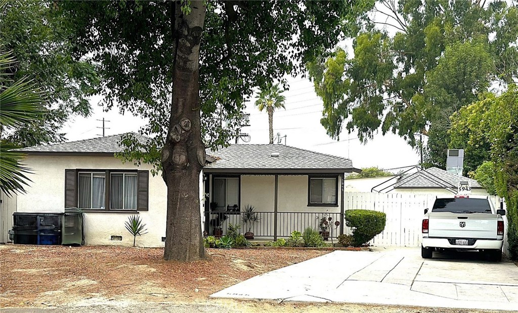 a front view of a house with a tree in front