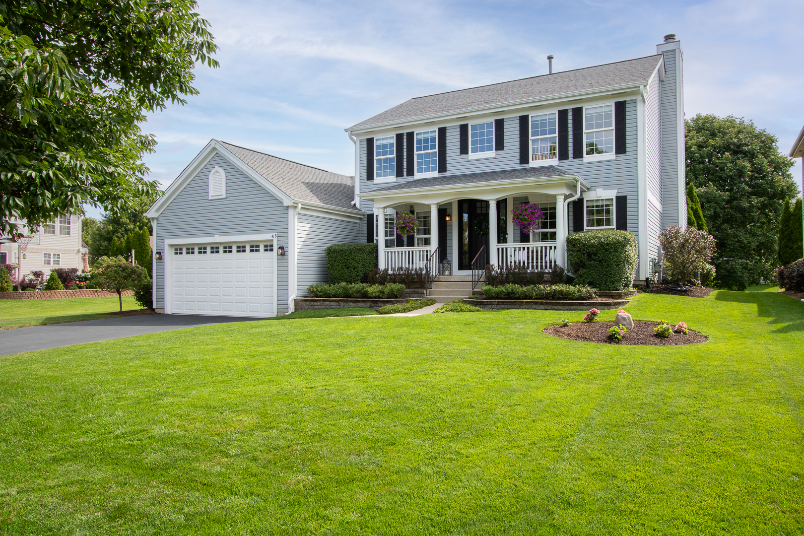 a front view of a house with yard and green space