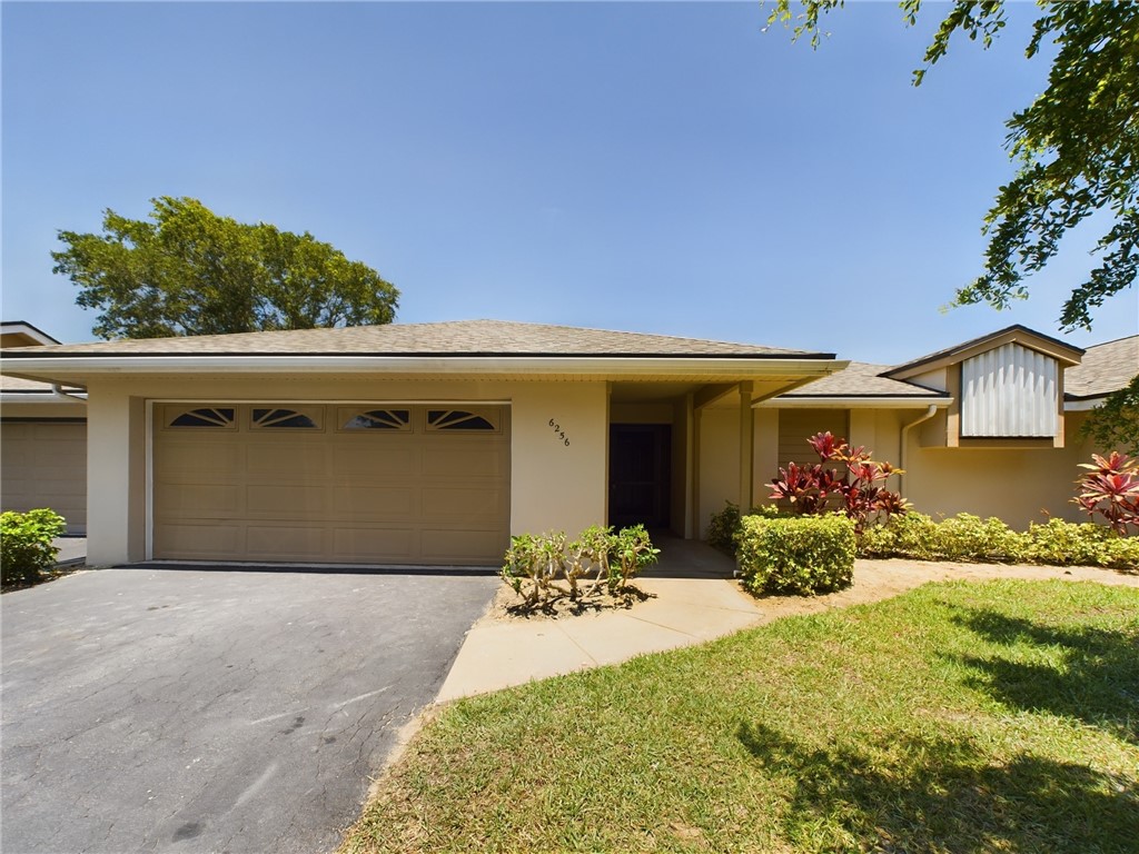 a front view of a house with a yard and a garage