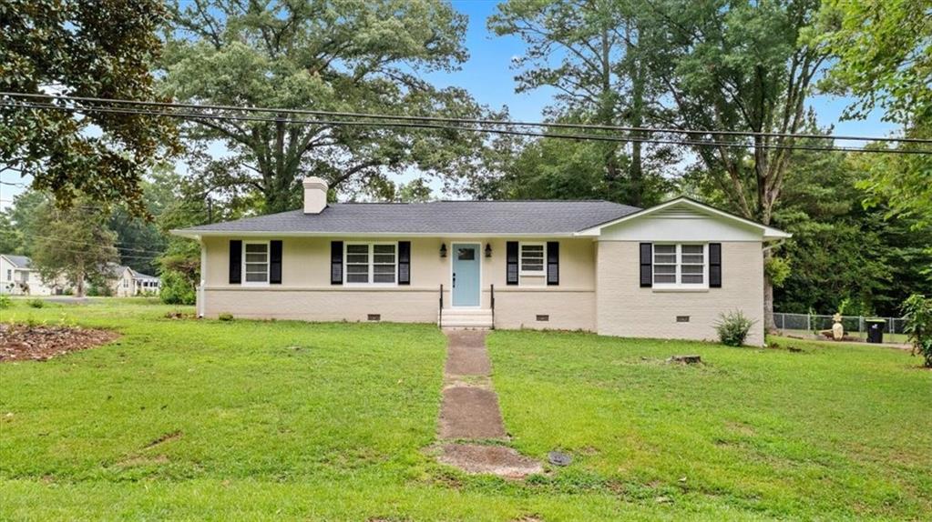 a front view of a house with a yard and trees