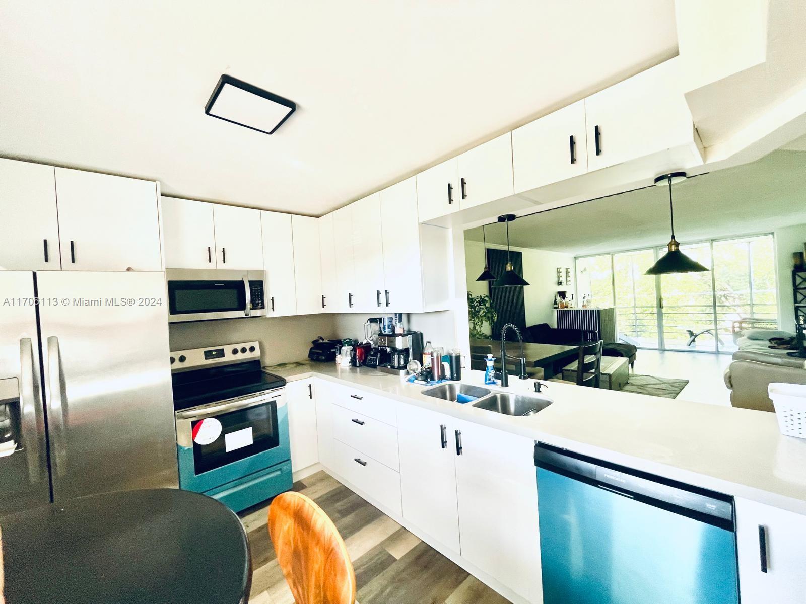 a kitchen with stainless steel appliances kitchen island granite countertop a sink and cabinets