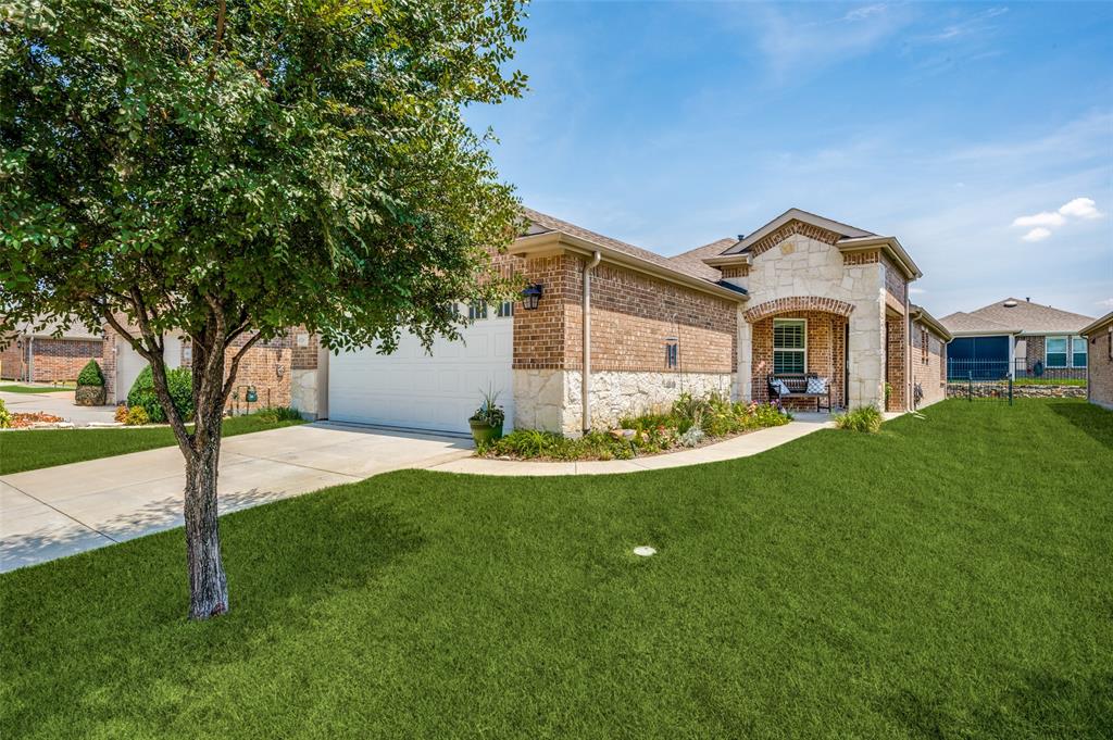 View of front facade featuring a front lawn and a garage