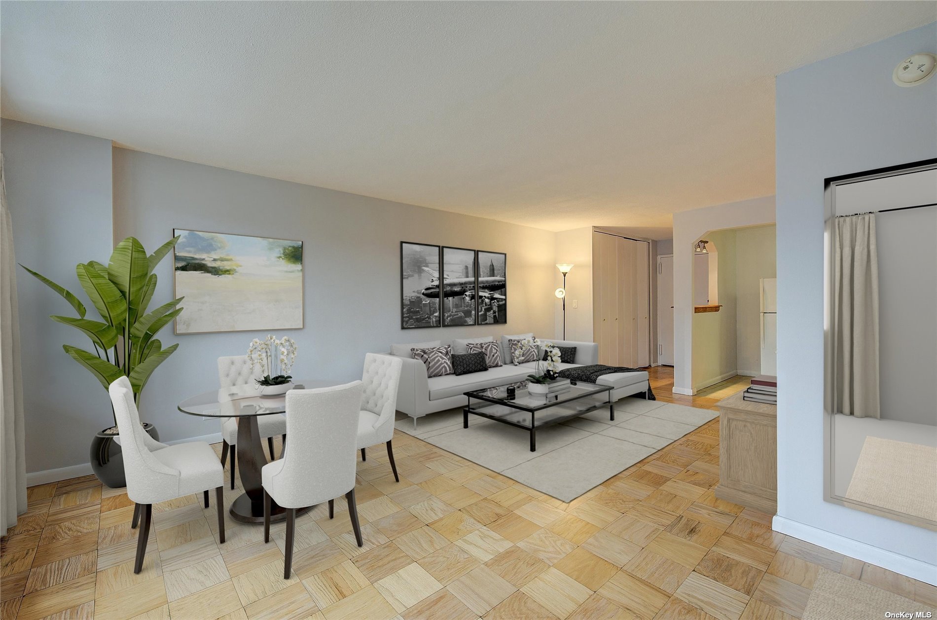 a living room with furniture a wooden floor and a potted plant