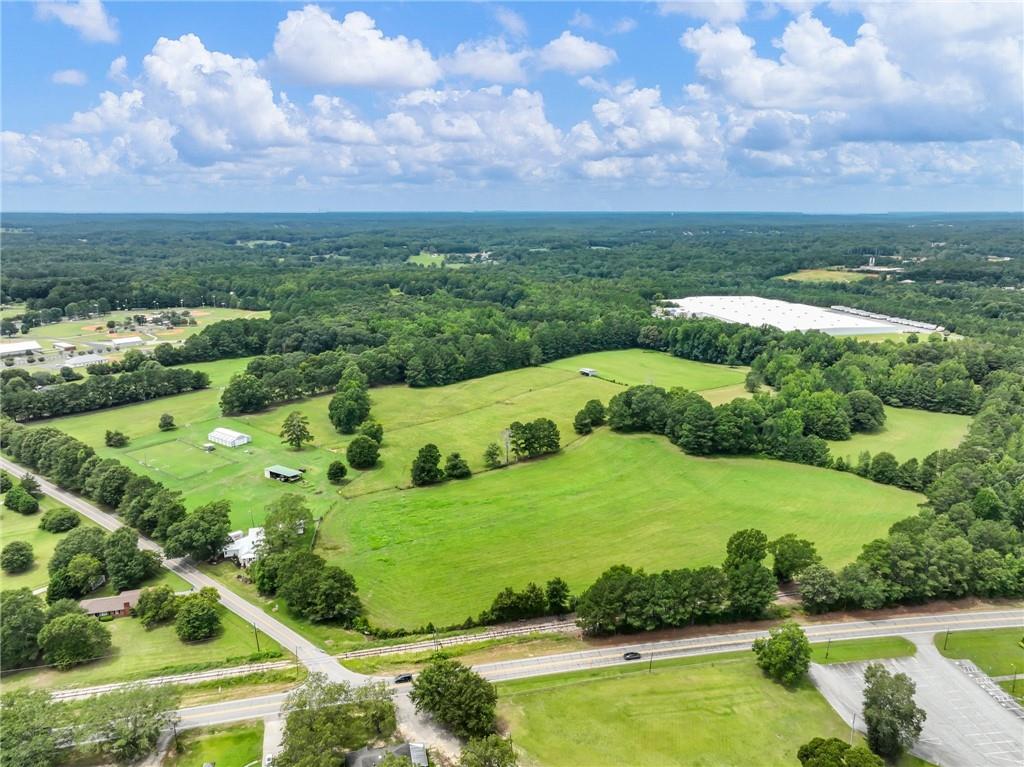 an aerial view of a residential houses with outdoor space and trees all around