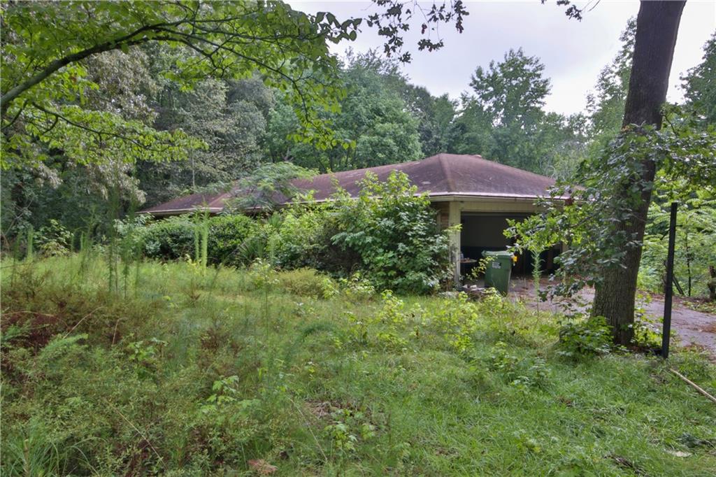 a view of a garden with a barbeque and trees