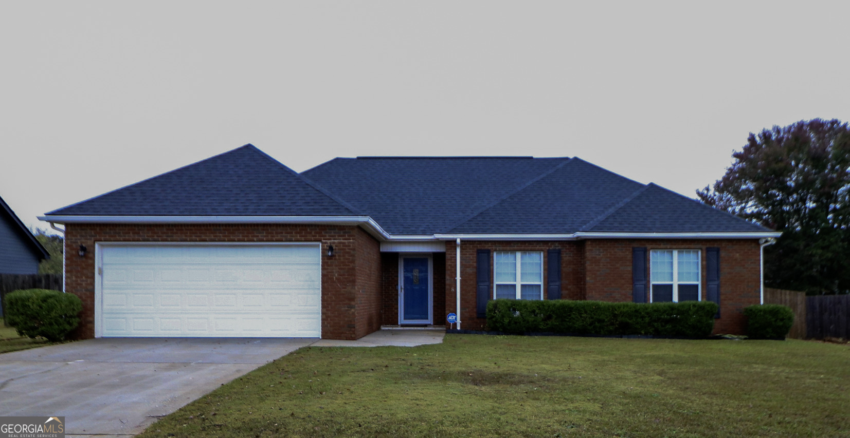 a front view of a house with a garden and yard