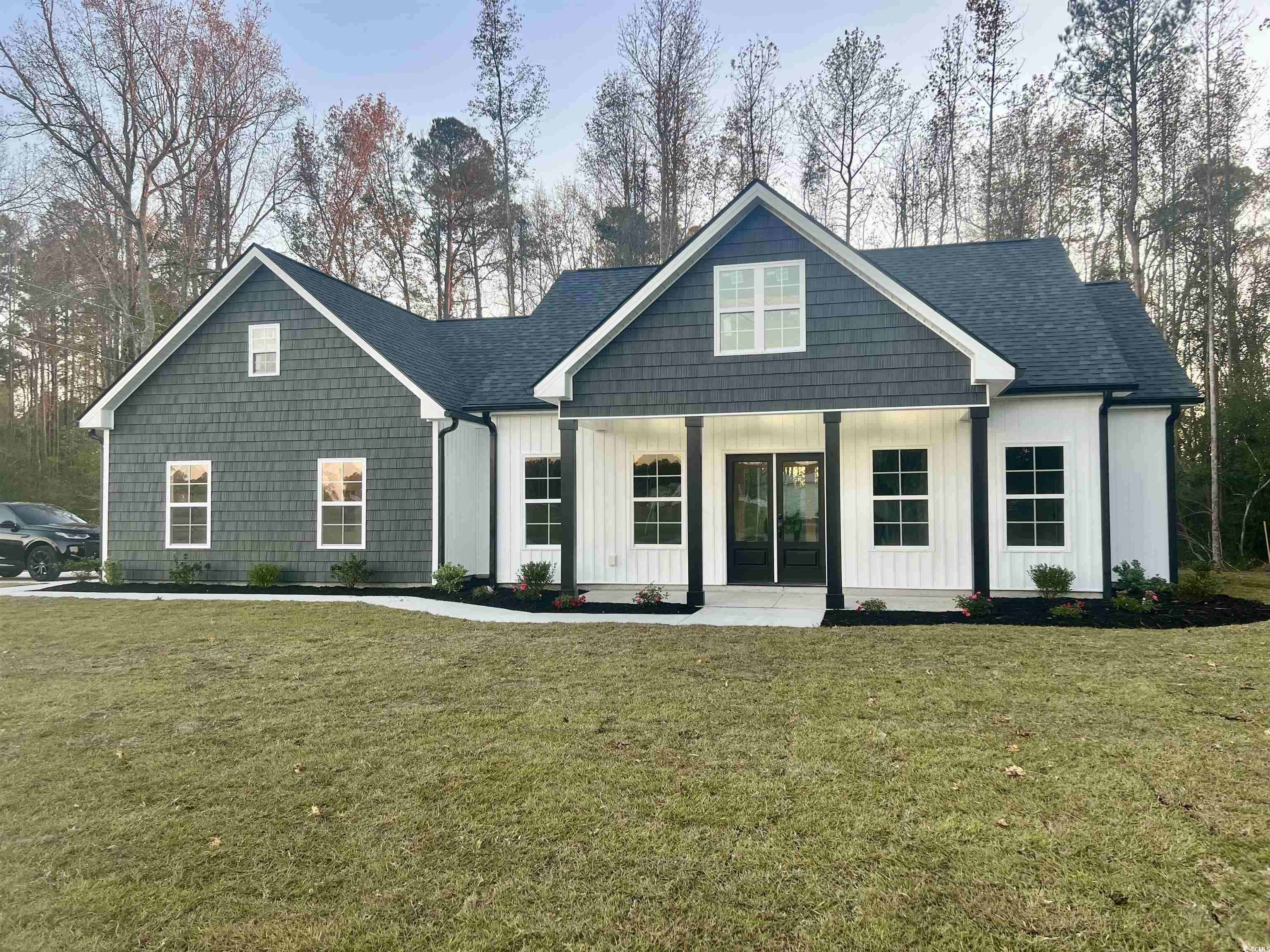 View of front of house with a porch and a front la