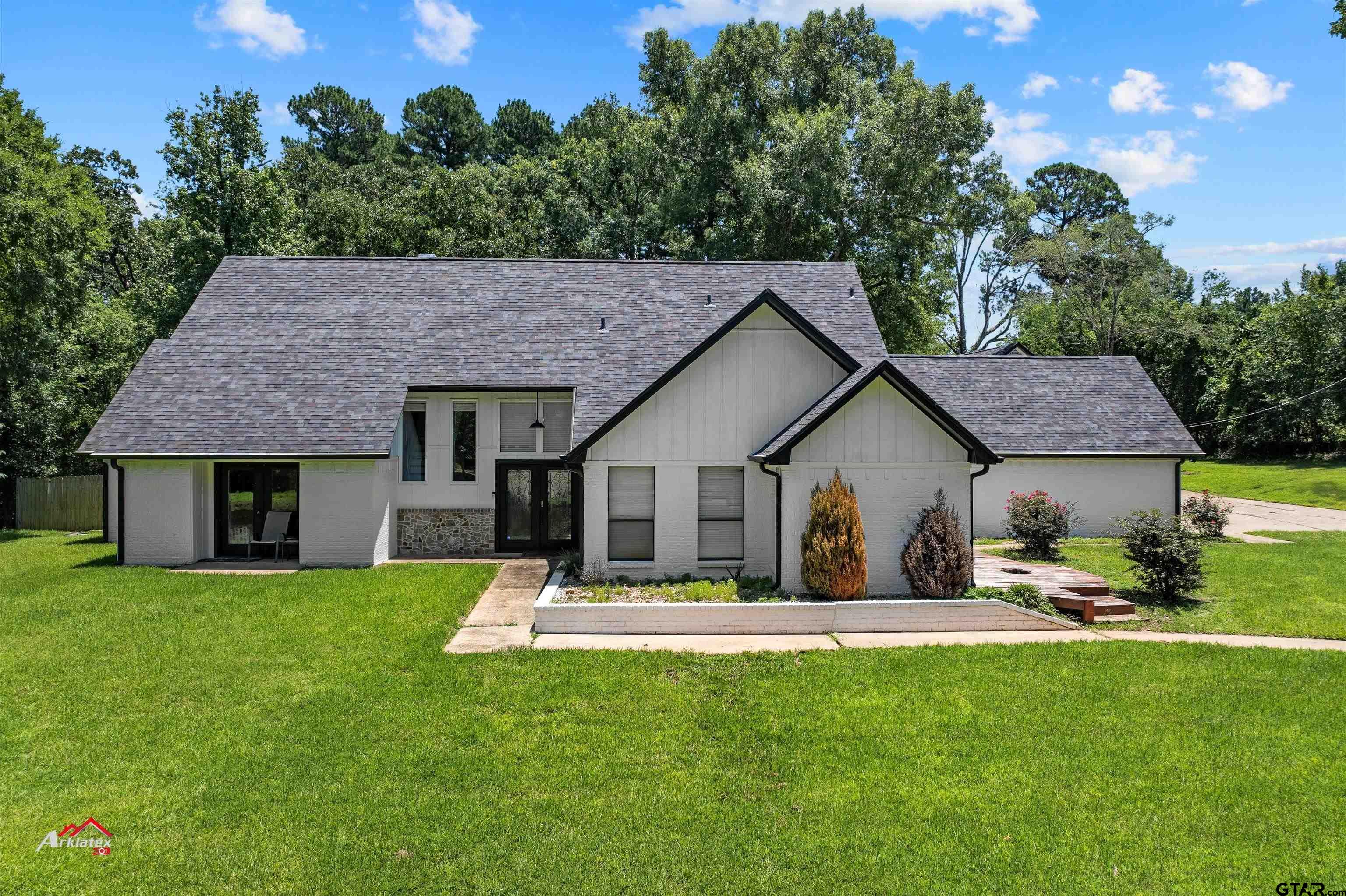 a front view of a house with a yard and trees