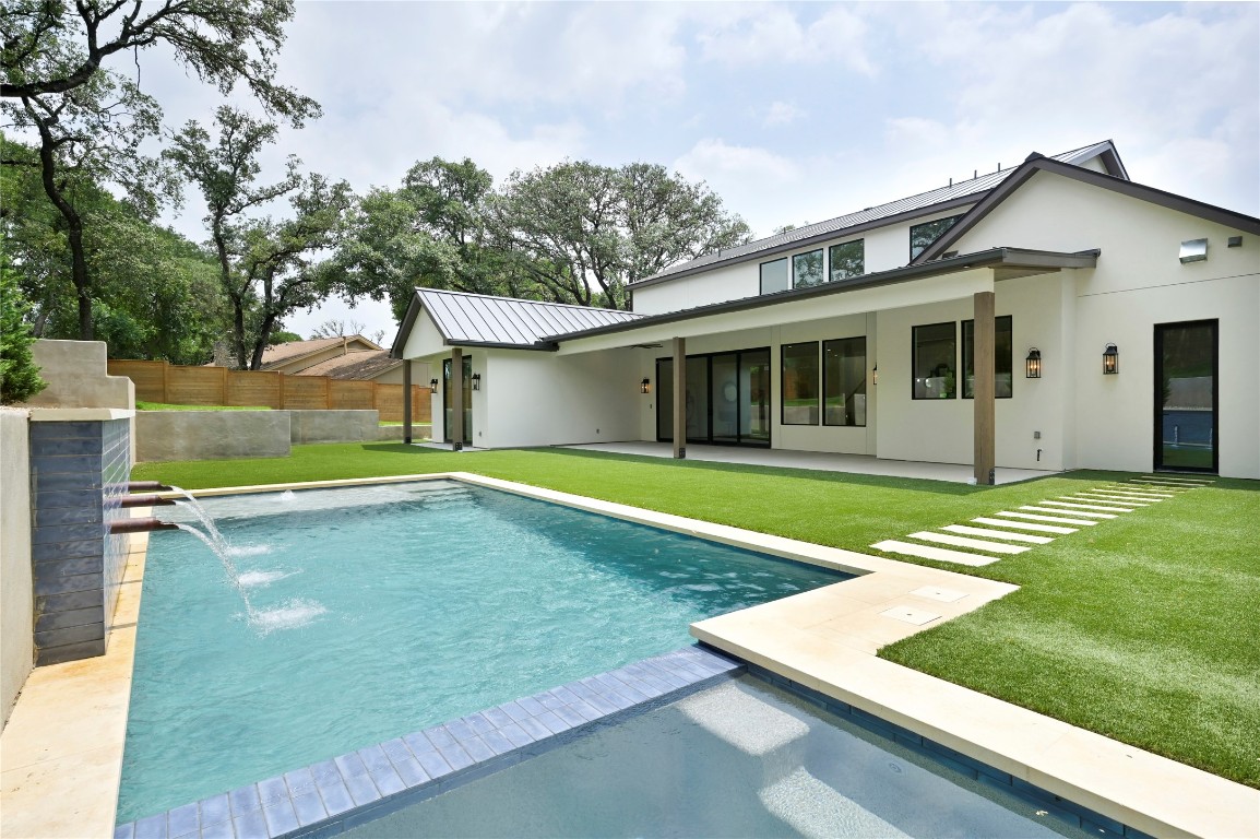 a view of a house with pool and a yard