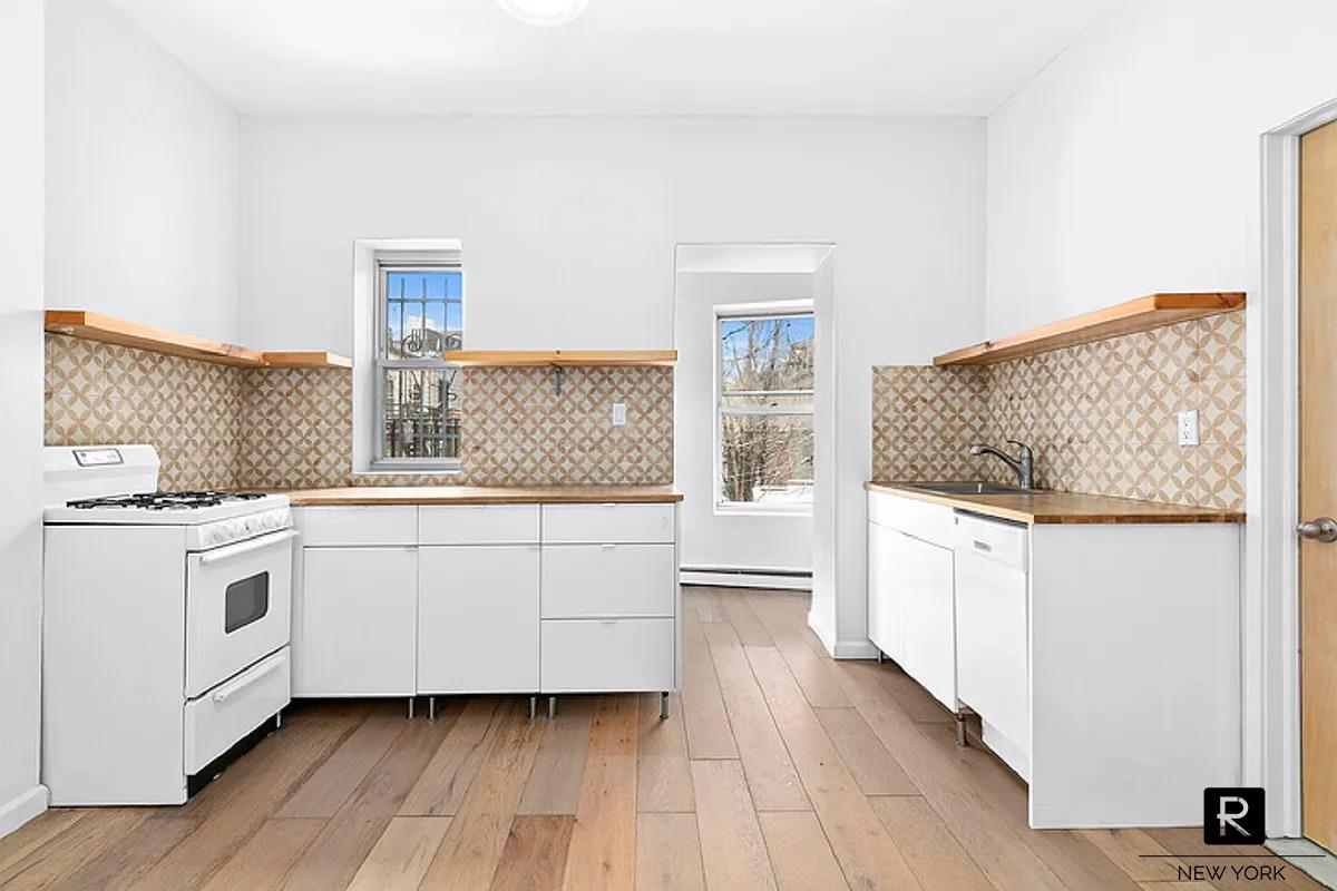 a kitchen with white cabinets and white appliances