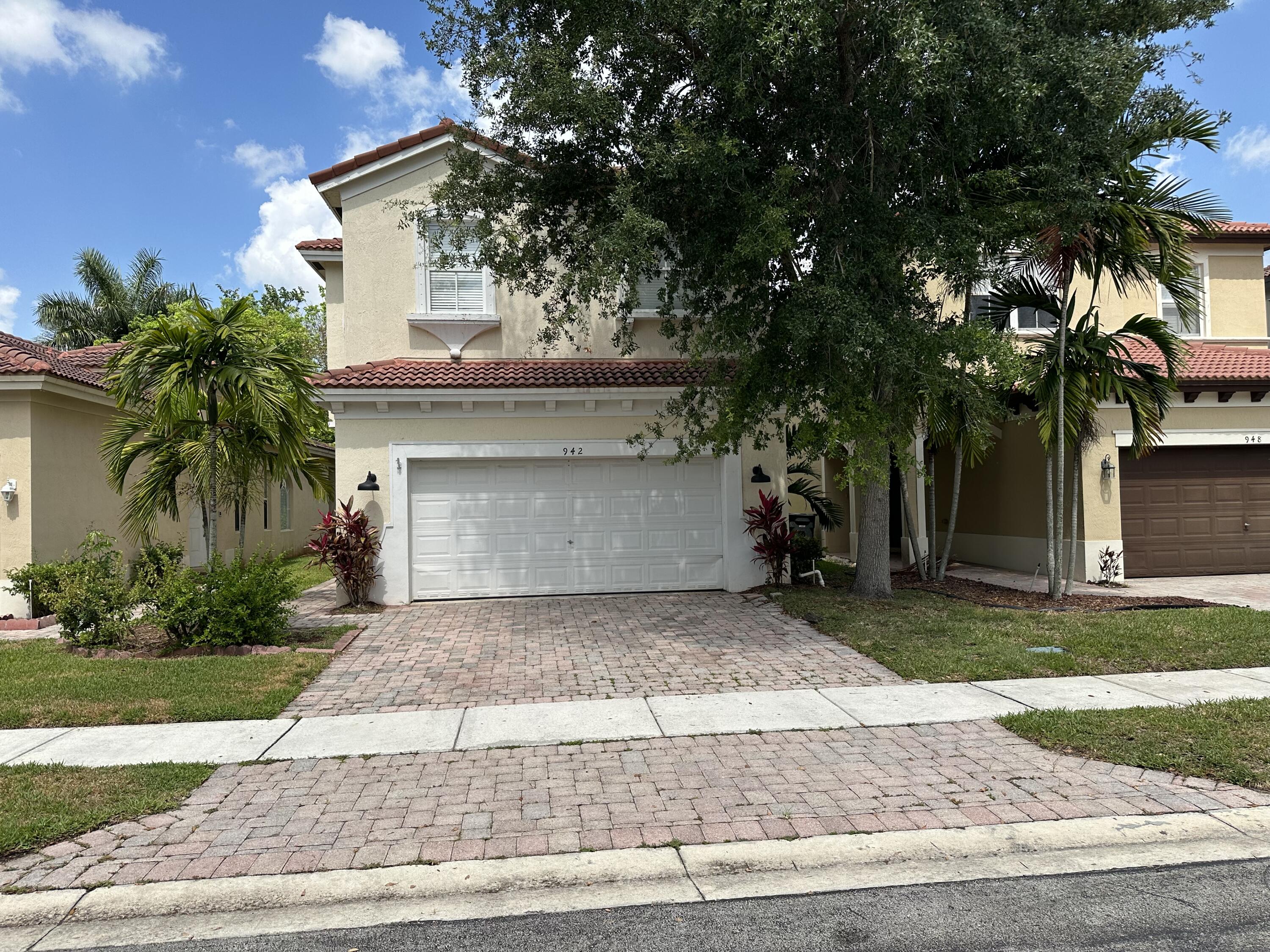 a front view of a house with a yard and a garage