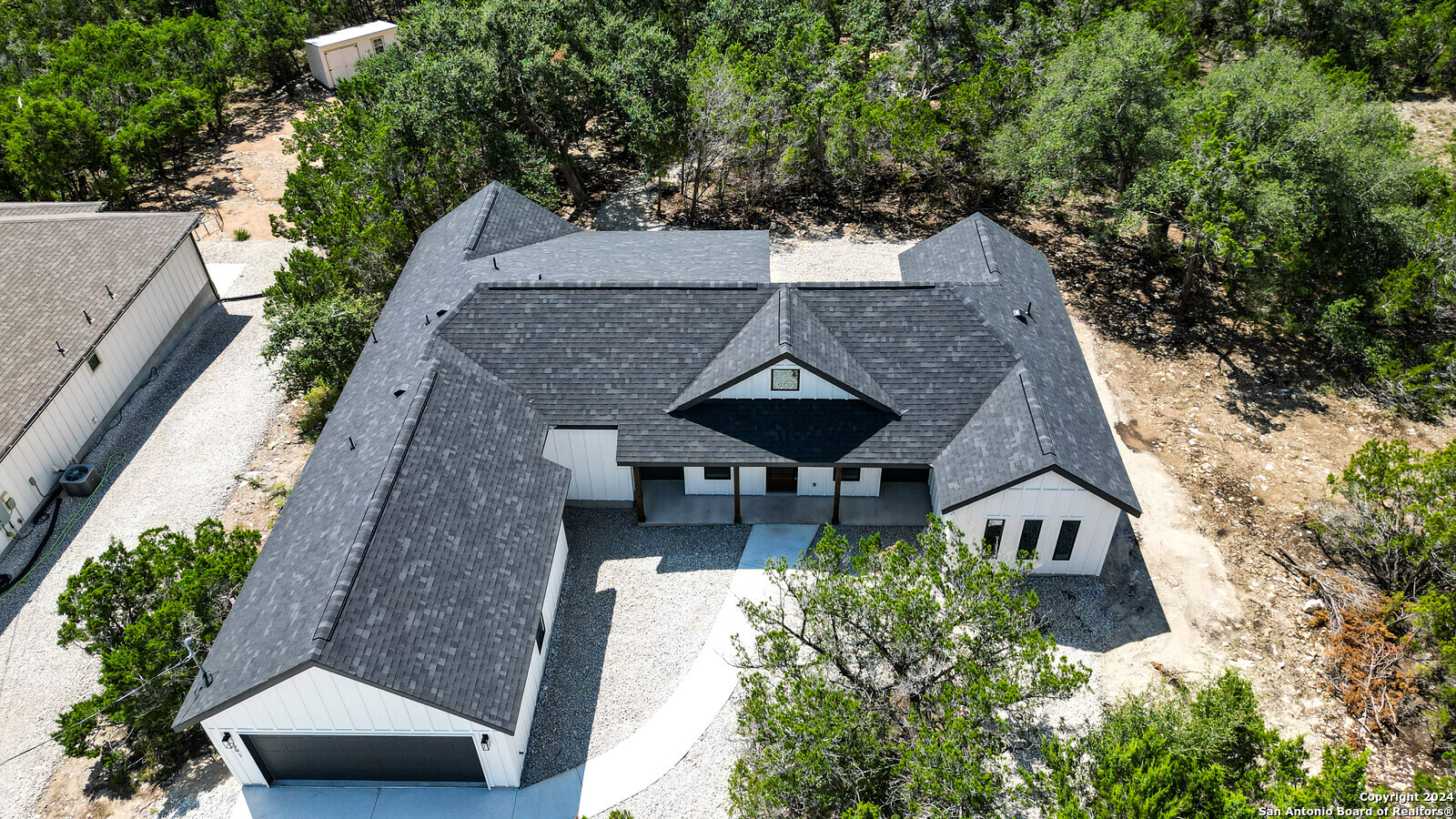 an aerial view of a house with a yard potted plants and large tree