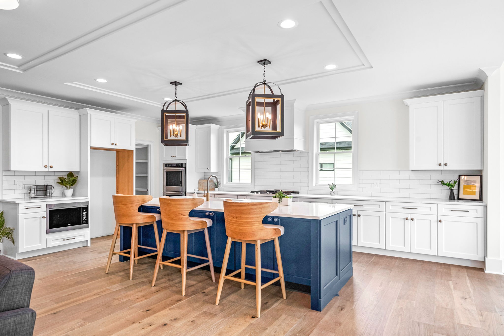 a large kitchen with cabinets chairs and wooden floor