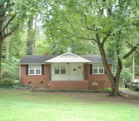 a front view of a house with a garden and trees