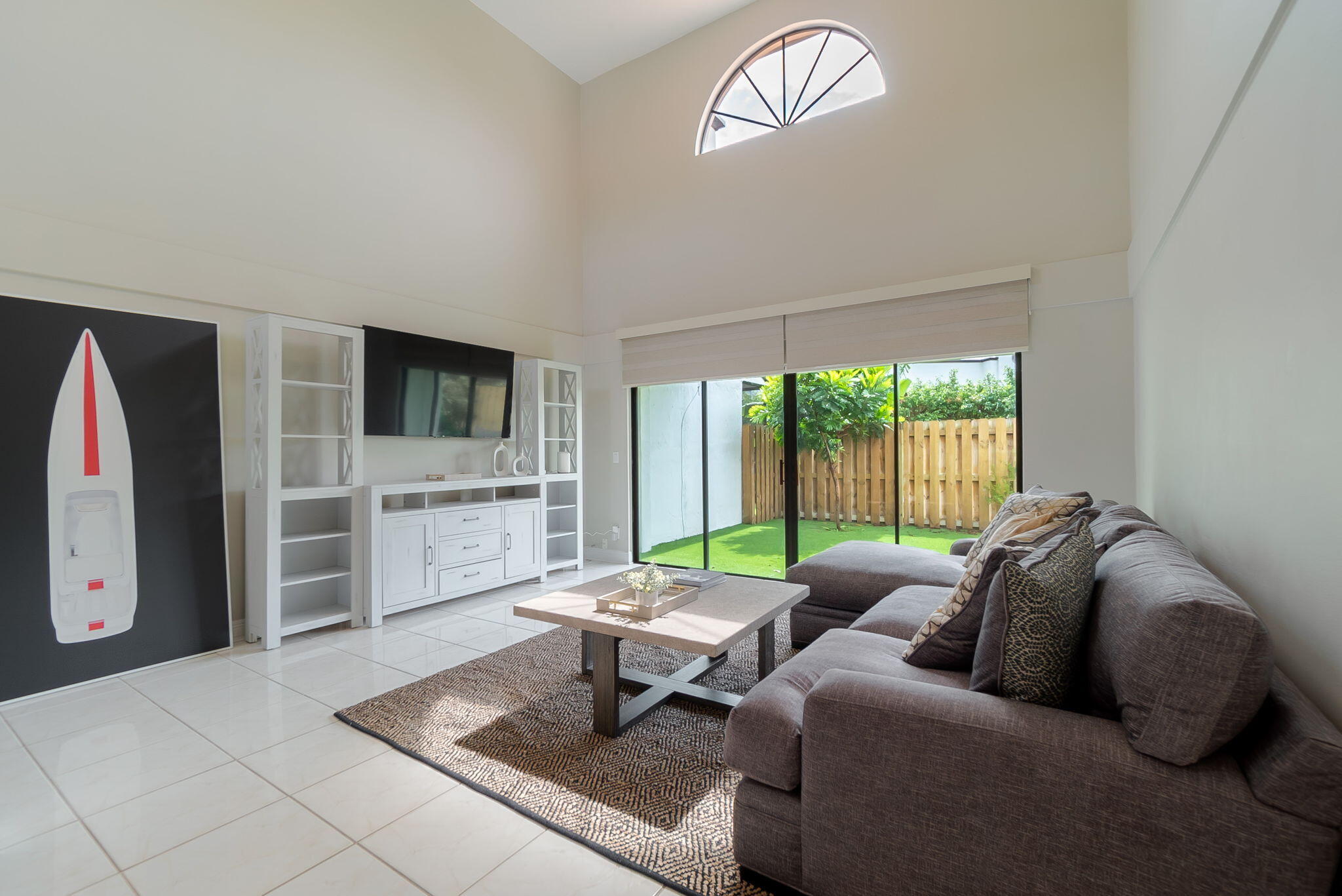 a living room with furniture a rug and a floor to ceiling window