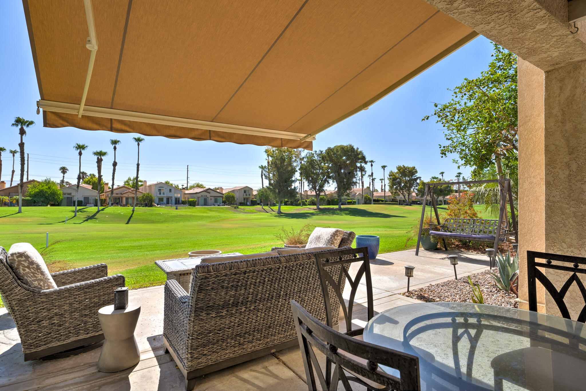 a view of a swimming pool and lounge chairs in back yard of the house