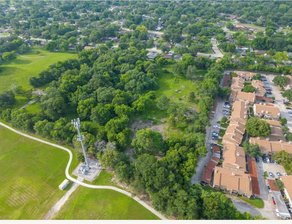 an aerial view of residential houses with outdoor space and trees