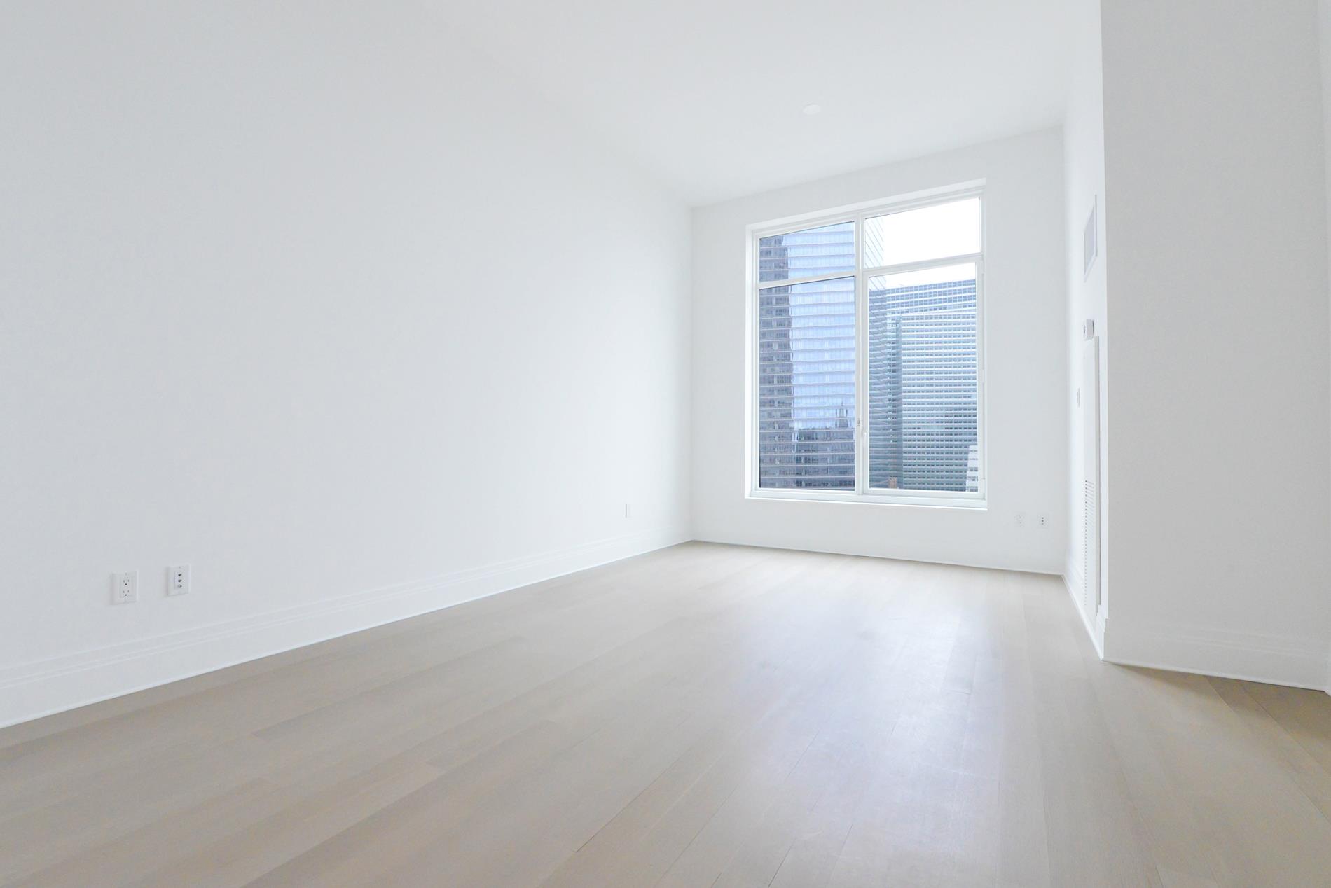 an empty room with windows and closet