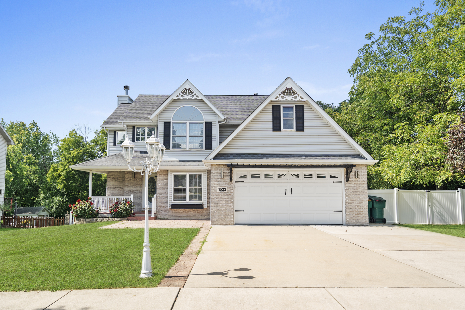 a front view of a house with a yard and trees