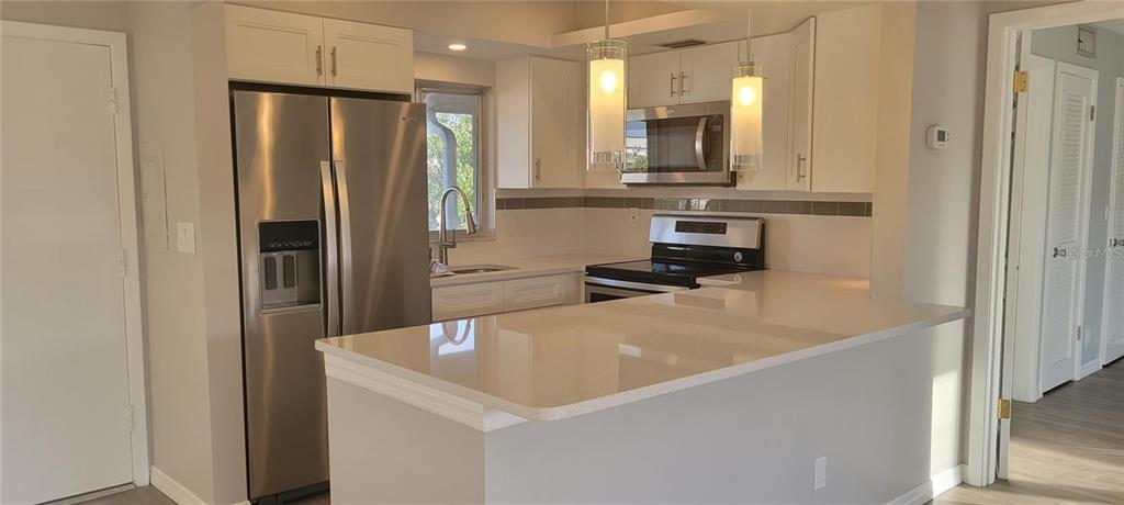 a kitchen with stainless steel appliances a refrigerator and a stove