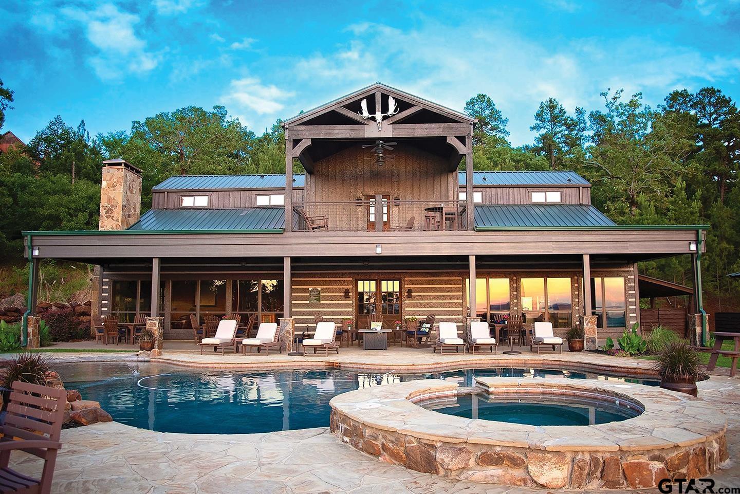 a front view of a house with swimming pool and furniture