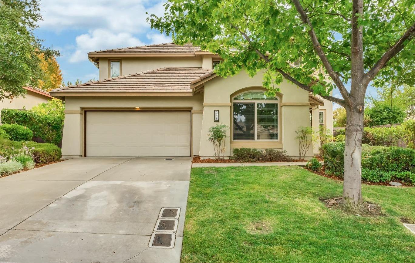 a front view of a house with a yard and trees