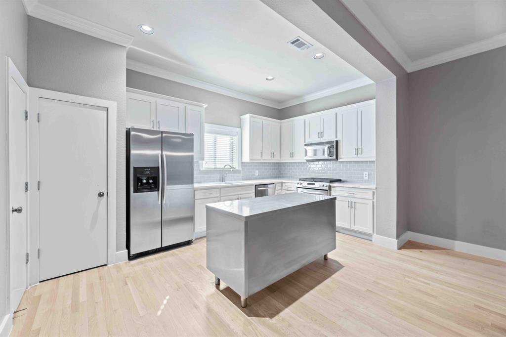 a kitchen with stainless steel appliances granite countertop a refrigerator and a sink