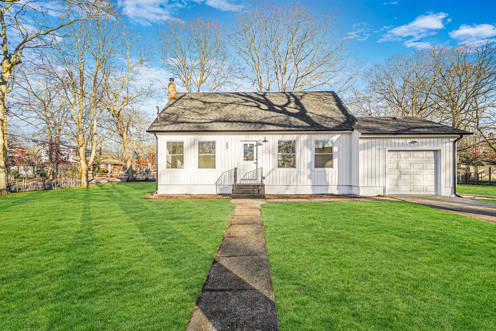 View of front of property with a front yard and a garage