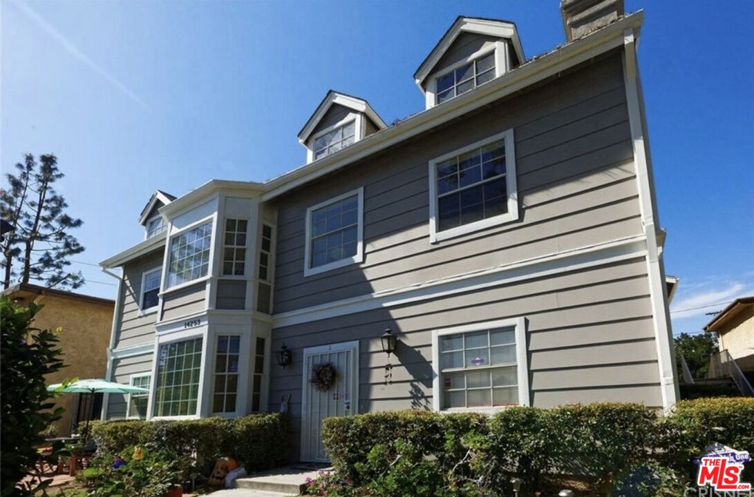 a front view of a house with plants