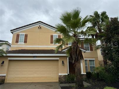 a front view of a house with a tree