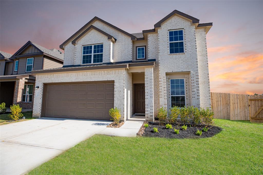 a front view of a house with a yard and garage