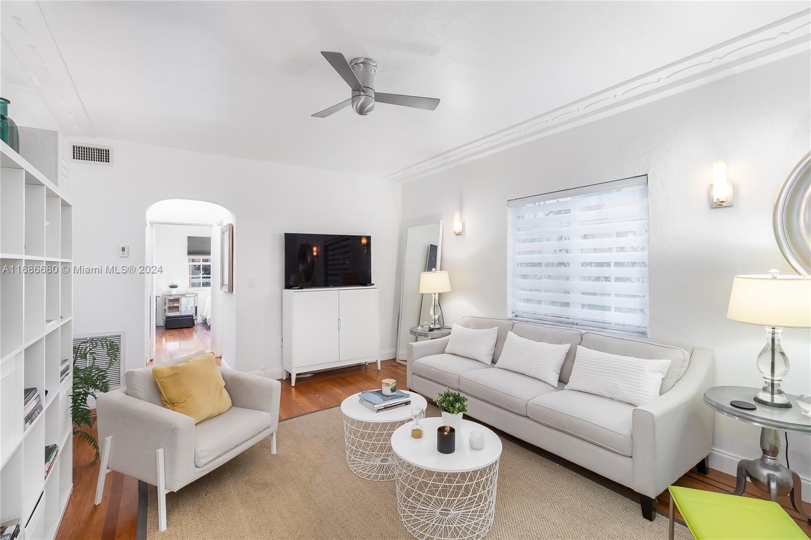 a living room with furniture a flat screen tv and a window