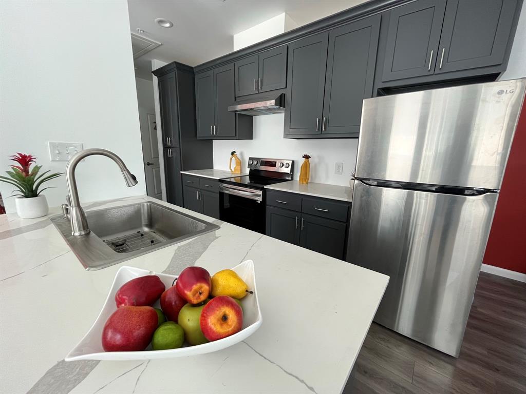 a kitchen with stainless steel appliances a refrigerator sink and cabinets